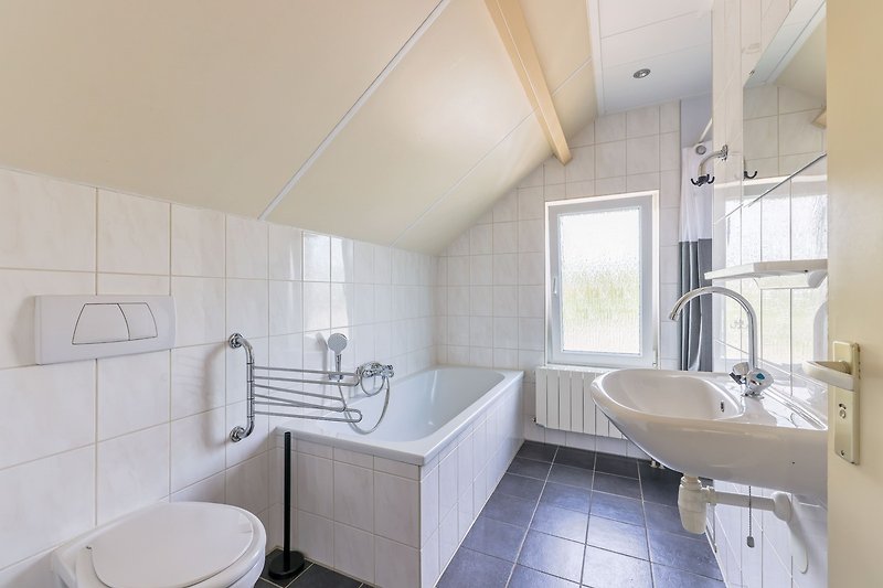 Ein modernes Badezimmer mit stilvollem Spiegel und Waschbecken.