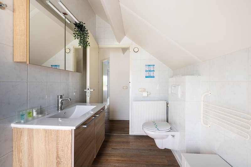 Ein stilvolles Badezimmer mit elegantem Spiegel und modernem Waschbecken.