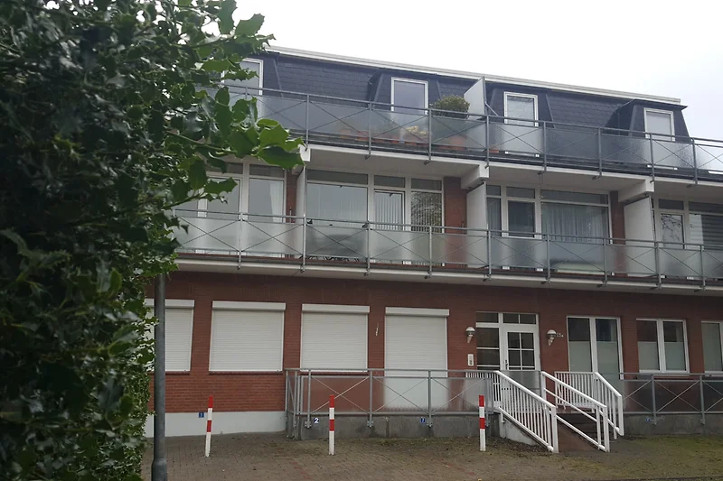 Moderne appartement met balkon, ramen en houten panelen.