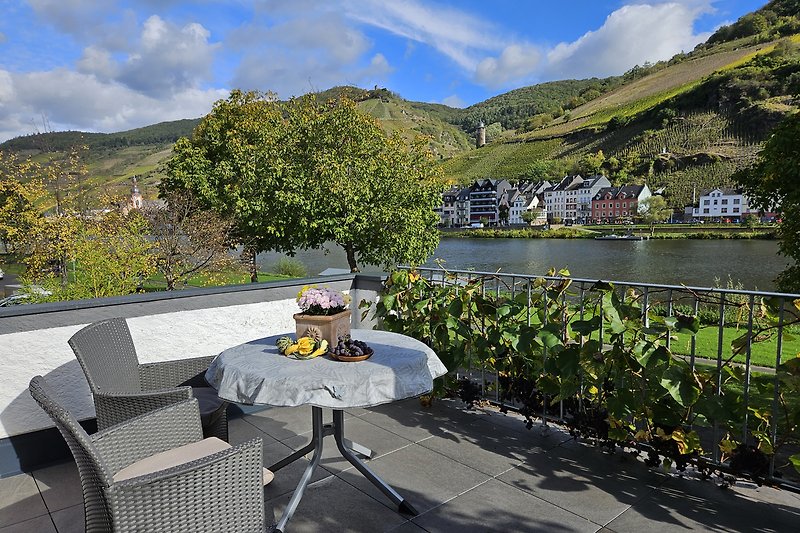 Eine idyllische Terrasse mit Blick auf Berge und See. Entspannen Sie sich im Freien auf bequemen Möbeln.