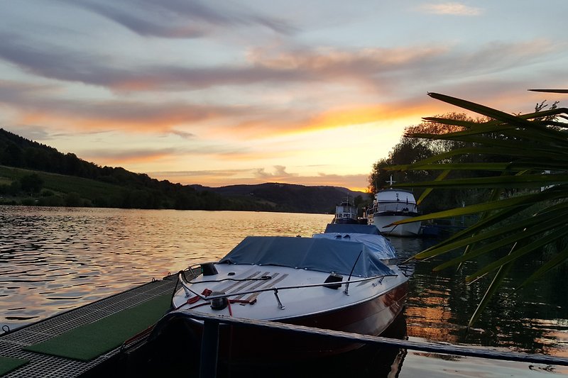 Boot auf ruhigem See bei Sonnenuntergang.