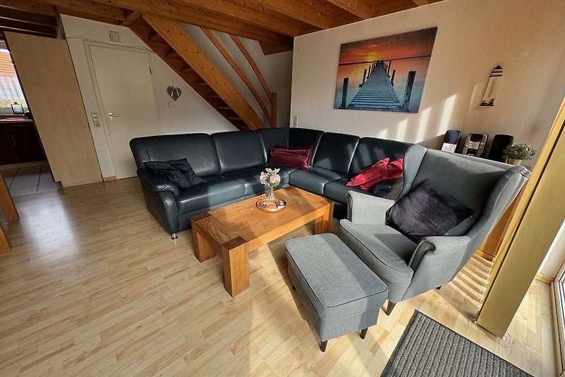 Wohnzimmer mit bequemer Couch, Tisch, Lampe und Fenster. Gemütliche Atmosphäre.