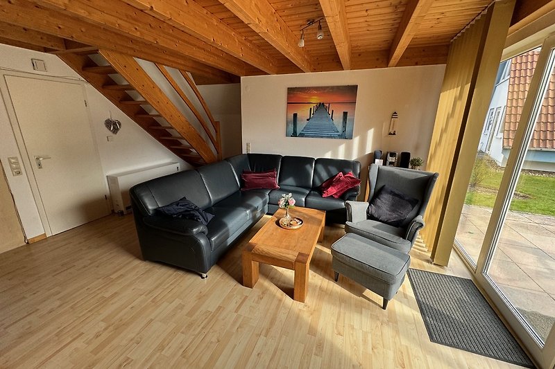 Wohnzimmer mit bequemer Couch, Holzmöbeln und Terrassentür. Gemütliche Atmosphäre.
