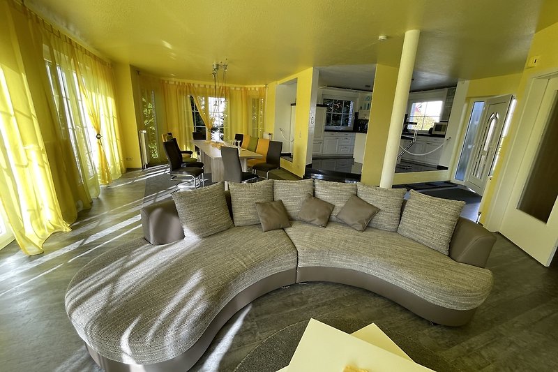 Stilvolles Wohnzimmer mit gelber Dekoration und großem Fenster.