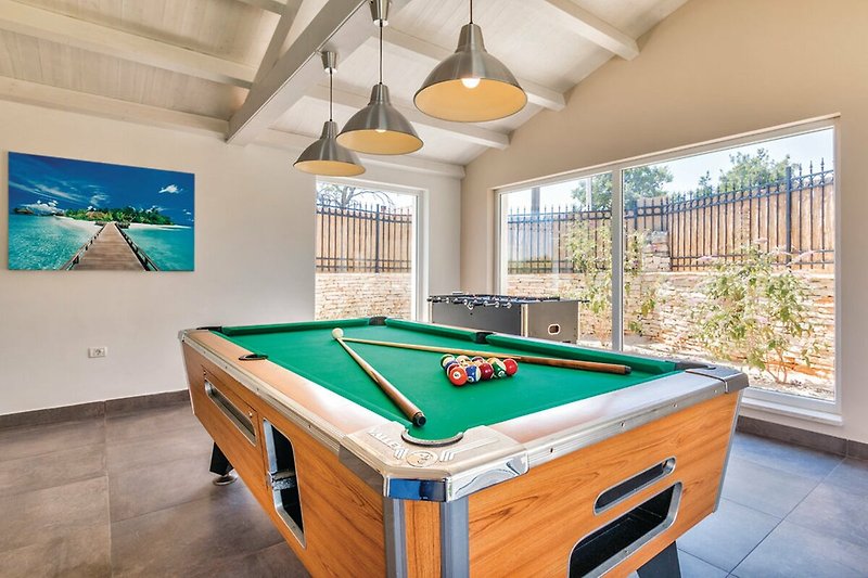 Spacious recreation room with billiard table, pool, and wood accents.