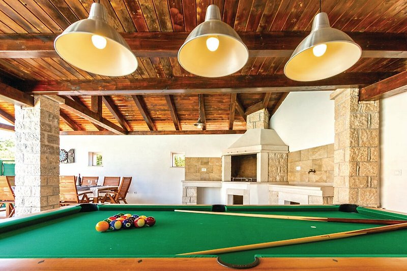 Rent this billiard room with a baize table, sports equipment, and stylish lighting.