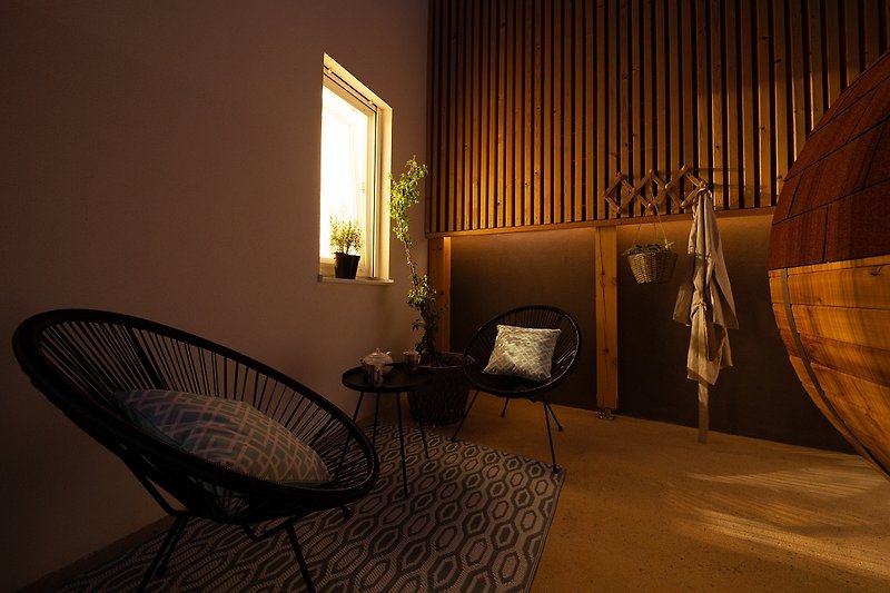 Dunkler Raum mit Holzmöbeln und Pflanzen. Gemütliche Beleuchtung.