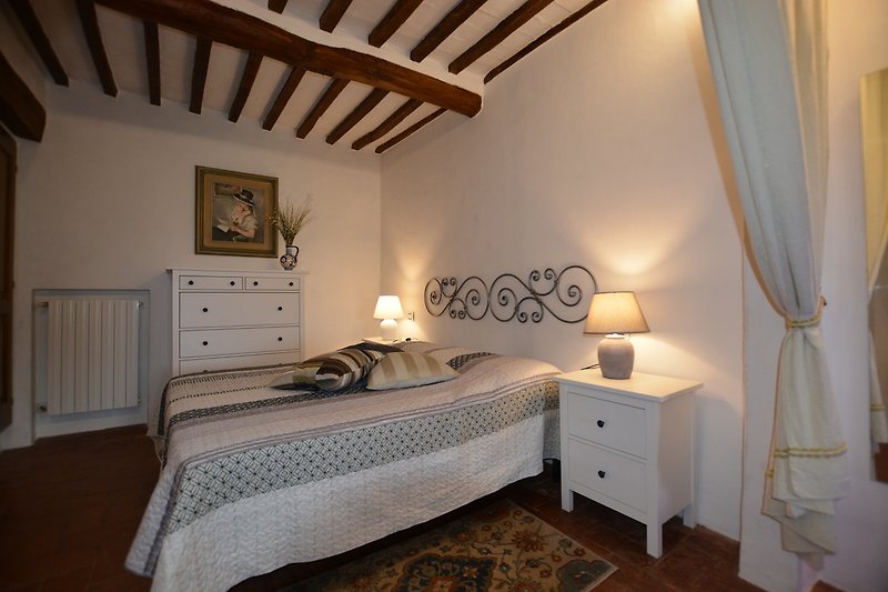 Una camera da letto confortevole con mobili in legno e una lampada a sospensione.