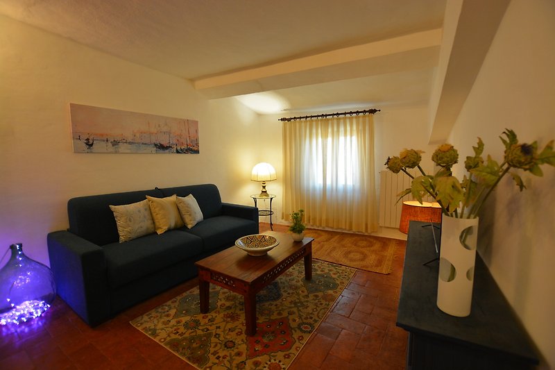Un soggiorno accogliente con mobili, lampada e piante.