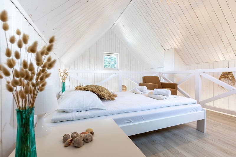 Pięknie urządzone wnętrze z drewnianymi meblami i wygodnym łóżkiem.