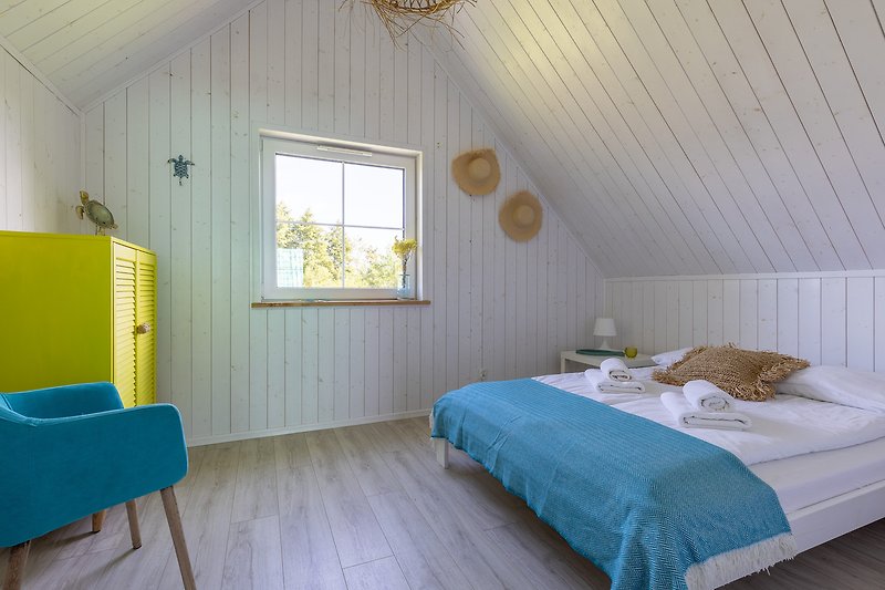Komfortowy pokój z drewnianym wykończeniem, wygodnym łóżkiem i elegancką zasłoną.
