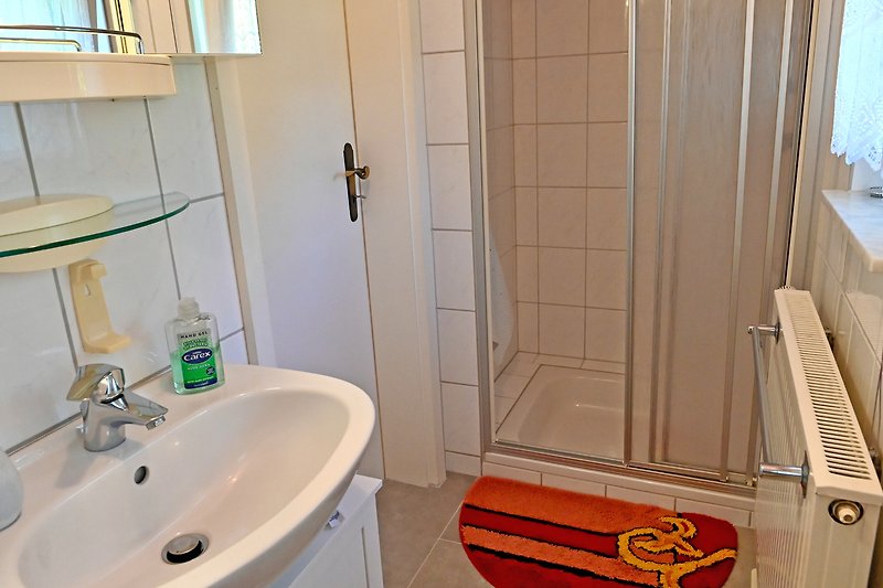 Ein stilvolles Badezimmer mit Spiegel, Waschbecken und Holzboden.