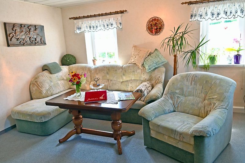 Gemütliches Wohnzimmer mit bequemer Couch, stilvoller Einrichtung und Pflanzen.