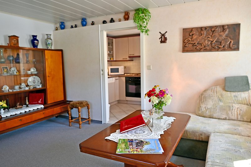 Gemütliches Wohnzimmer mit stilvoller Einrichtung, bequemer Couch und grünen Pflanzen.