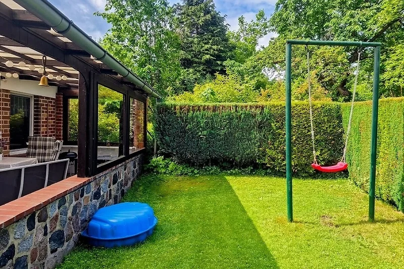 Ruhiger Garten mit gepflegtem Rasen und natürlichem Schatten.