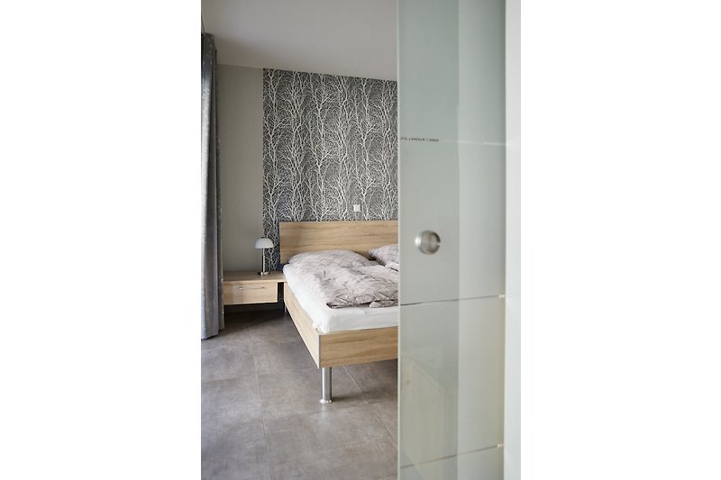 Gemütliches Schlafzimmer mit stilvollem Holzbett und eleganten Vorhängen. [de]