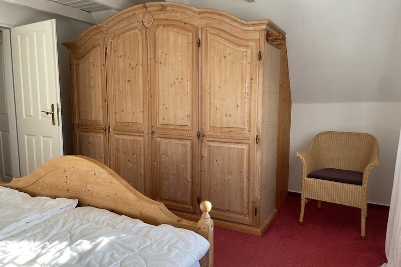 Gemütliches Schlafzimmer mit Doppelbett und Kleiderschrank