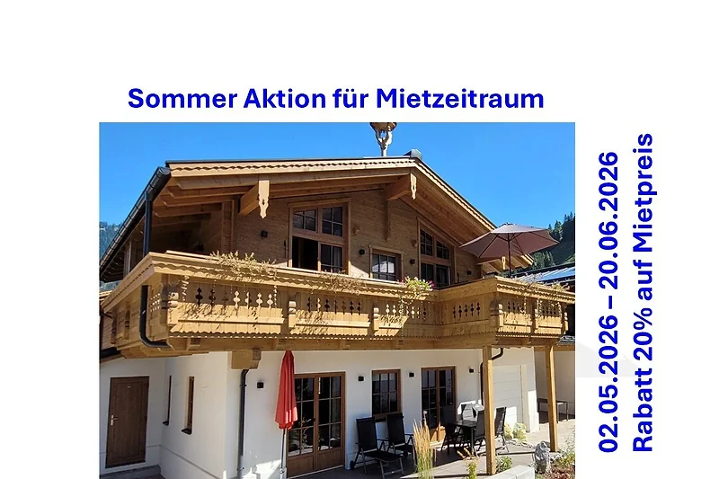 Traditionelles Landhaus mit markantem Dach, Balkon und Außensitzplatz.