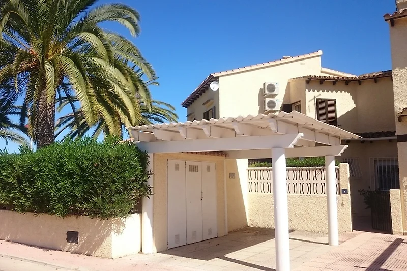 Het huis met carport en privétuin met eigen palmboom