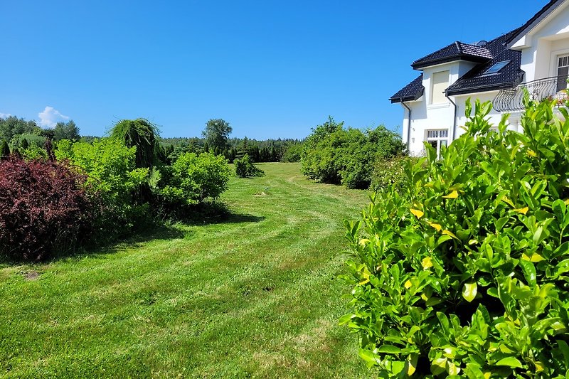 Schönes Ferienhaus mit grüner Landschaft und blauem Himmel.