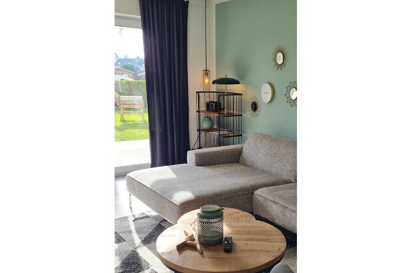 Modernes Wohnzimmer mit bequemer Couch, stilvoller Beleuchtung und Pflanzen. Gemütliche Atmosphäre.