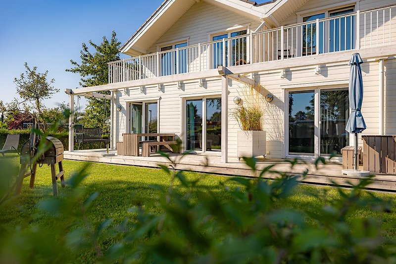 Einladende Veranda mit Holzplanken und gepflegtem Garten.