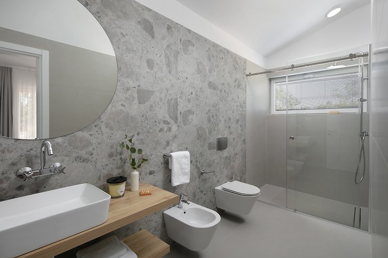 Ein stilvolles Ensuite- Badezimmer mit lila Akzenten und modernen Armaturen.