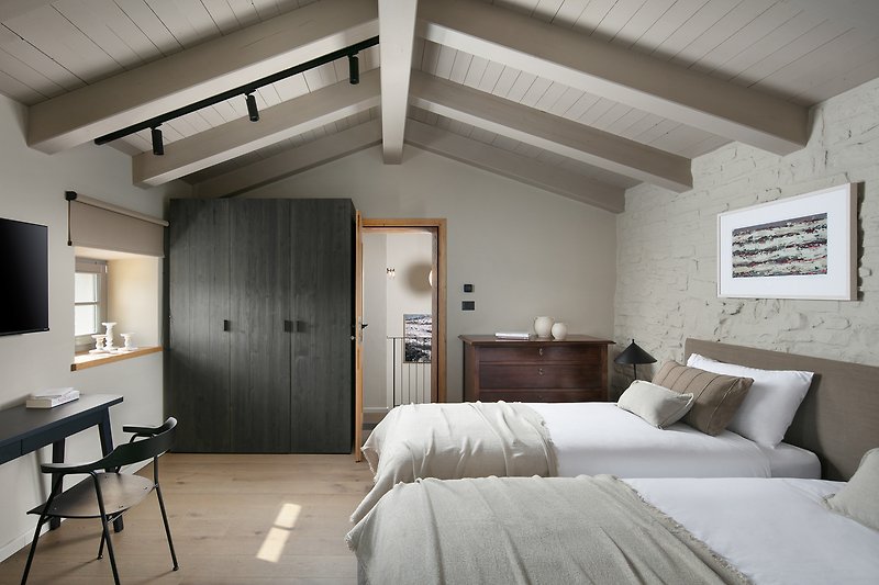 Entspannen Sie in diesem stilvoll eingerichteten Raum mit gemütlichem Holzmobiliar und genießen Sie den Komfort und die Ruhe.