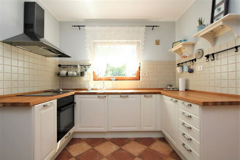 Kochen Sie in dieser geschmackvollen Landhaus-Küche mit großem Fenster und schöner Aussicht.