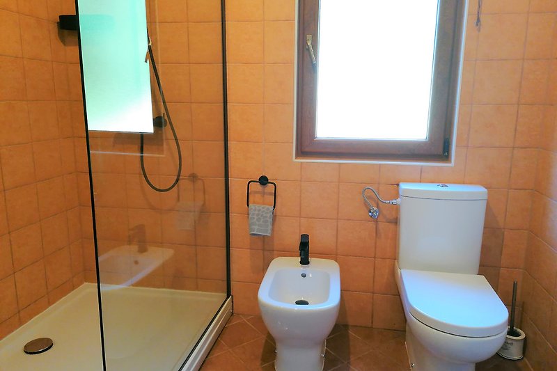 Großzügige Dusche mit Glaswand - Entspannen Sie in diesem modernen Badezimmer und genießen Sie die Annehmlichkeiten.