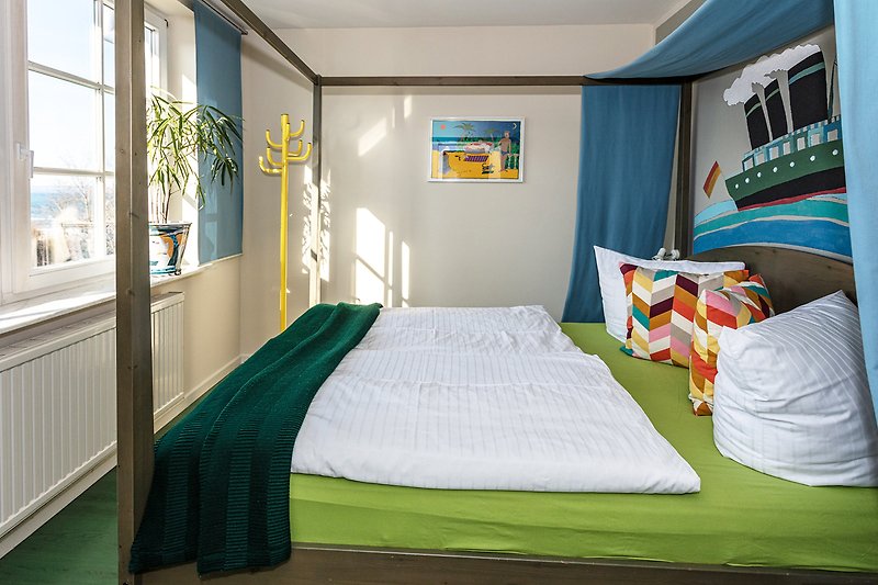 Das Schlafzimmer mit Doppelbett und seitlichem Seeblick.