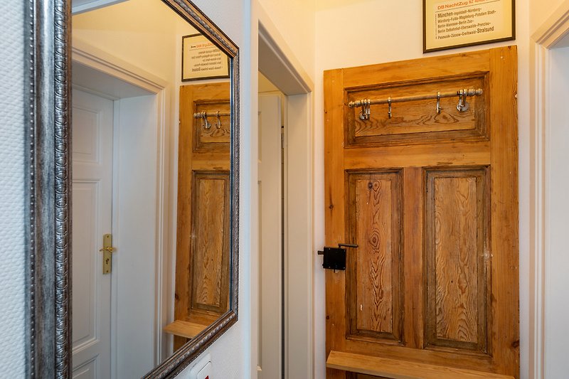 Le couloir avec le vestiaire. Au centre de l'image, la porte de la salle de bain.