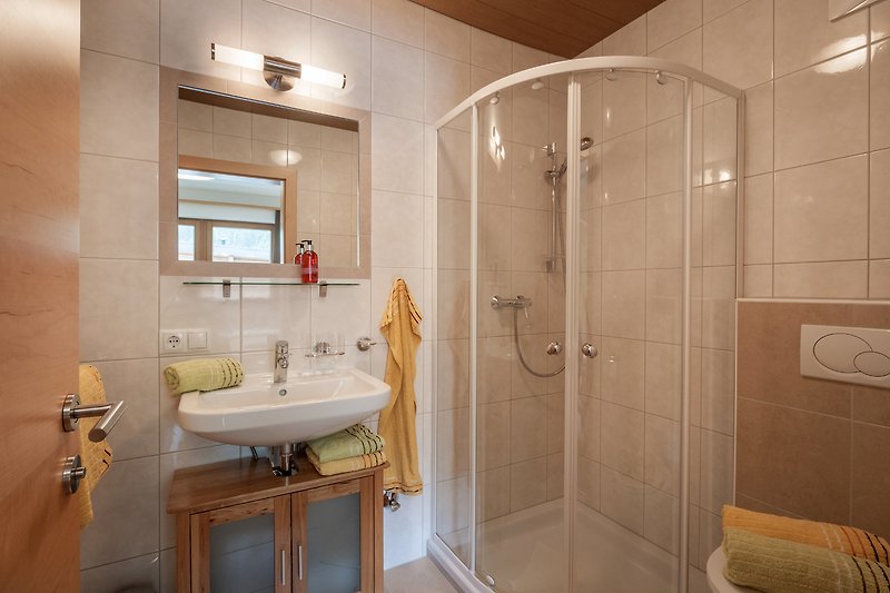 Entspannen Sie sich in diesem modernen Badezimmer mit luxuriöser Dusche und stilvollem Design. Genießen Sie Ihren Aufenthalt!