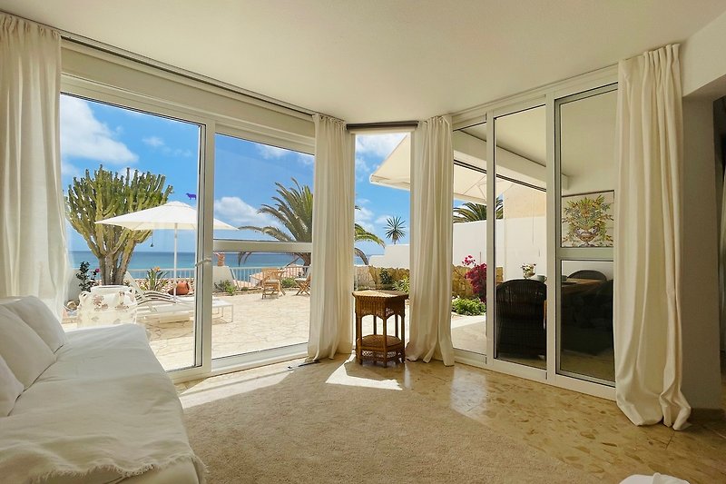 Strandhaus mit Meerblick, tropischer Landschaft und gemütlicher Einrichtung.