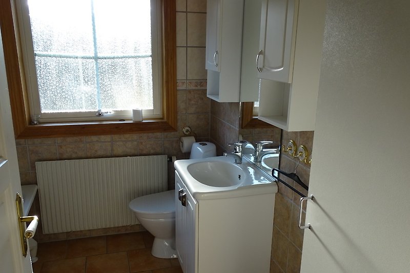Bathroom with bathtub, underfloor heating, shower and toilet.