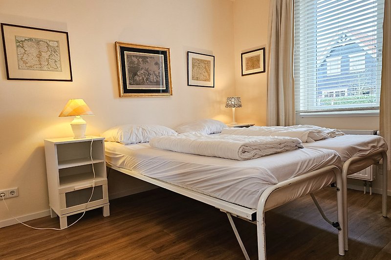 Gemütliches Schlafzimmer mit stilvollem Holzbett und hochwertiger Bettwäsche.