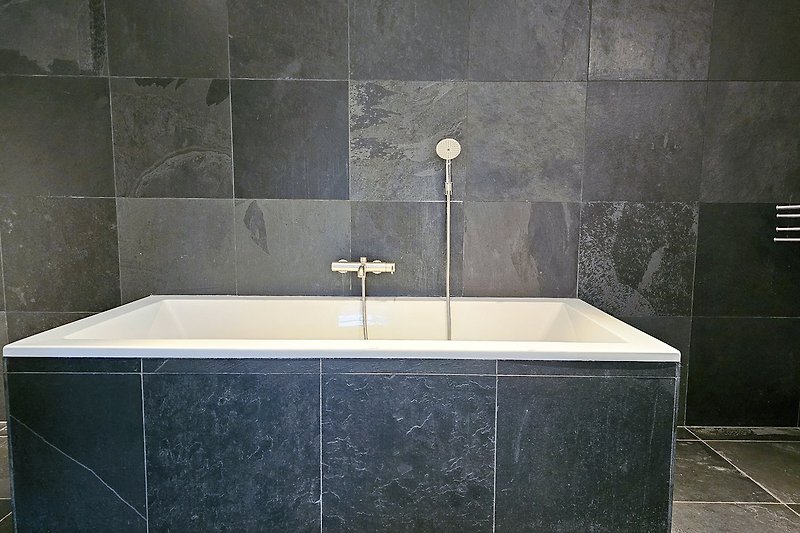 Stilvolles Badezimmer mit Badewanne und elegantem Design.