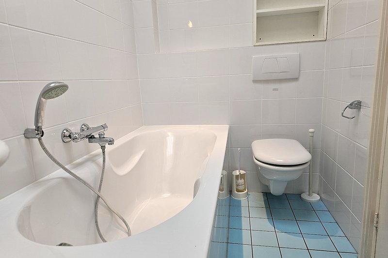 Schönes Badezimmer mit Holzboden, Keramikfliesen und ovaler Badewanne.