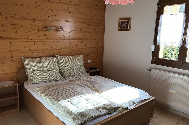 Mobilier en bois, lit confortable et décoration chaleureuse.