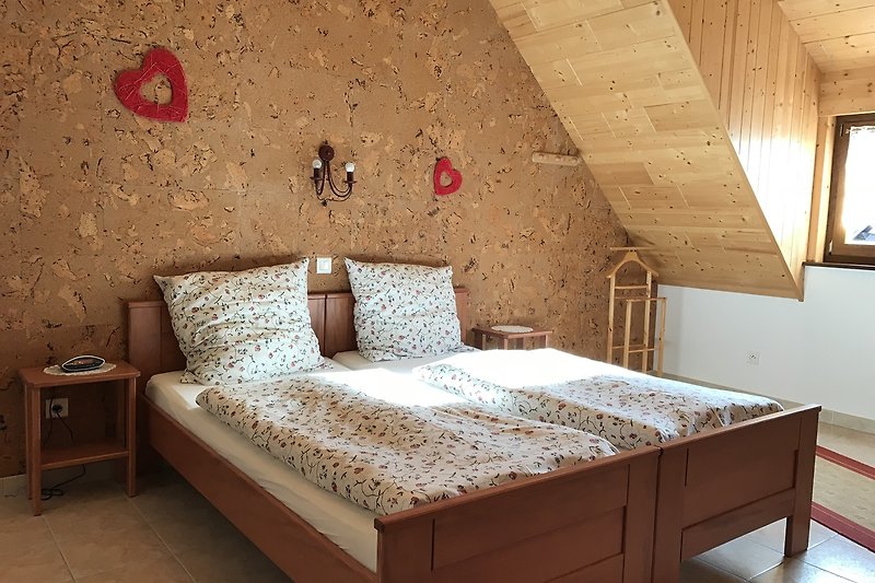 Une chambre confortable avec un lit en bois et une belle literie.