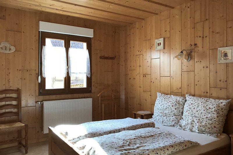 Une chambre confortable avec un lit en bois et une belle literie.