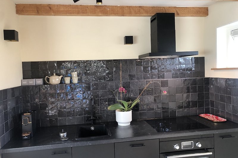 Moderne keuken met strakke kasten en granieten aanrecht.