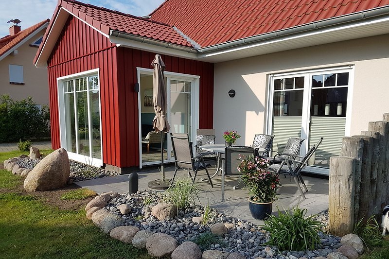 Terrasse mit Gartenmöbeln, Sonnenschirm und Grill