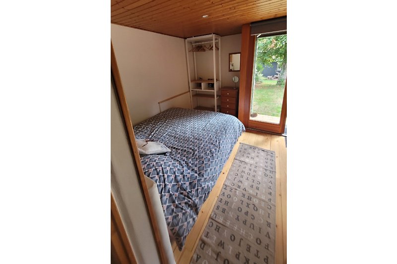 Une chambre confortable avec un lit en bois et une vue sur la nature.
