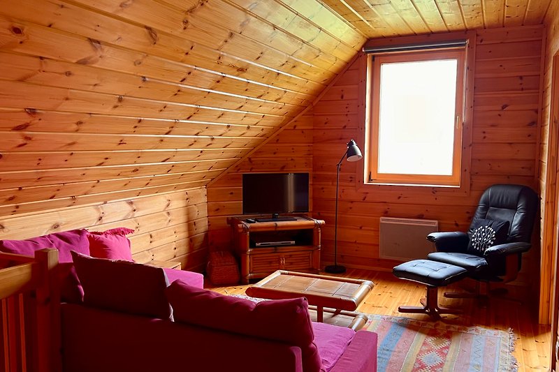 Wohnzimmer mit Holzmöbeln und gemütlicher Beleuchtung.