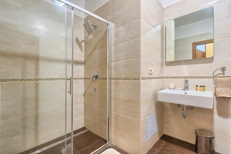 Prekrasna kupaonica s modernim namještajem i elegantnim zrcalom.