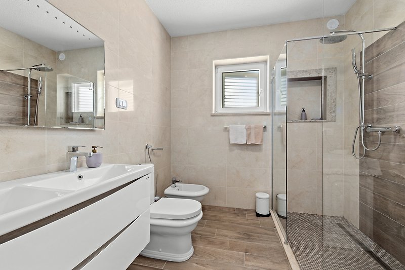 Moderan kupaonski prostor s ljubičastim detaljima i keramičkim umivaonikom.