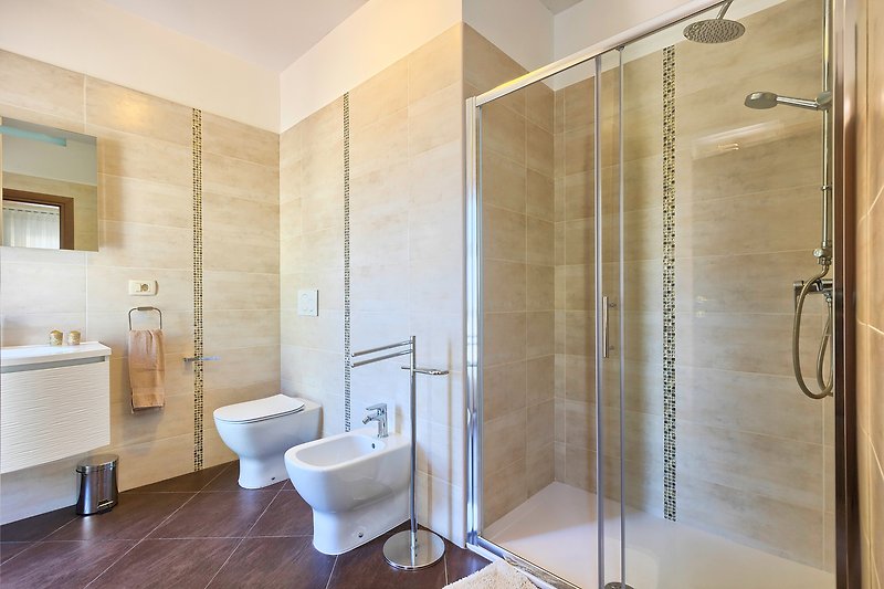 Luksuzna kupaonica s modernim namještajem i elegantnim zrcalom.