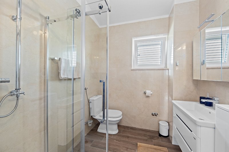Elegant bathroom with modern fixtures and stylish shower panel.