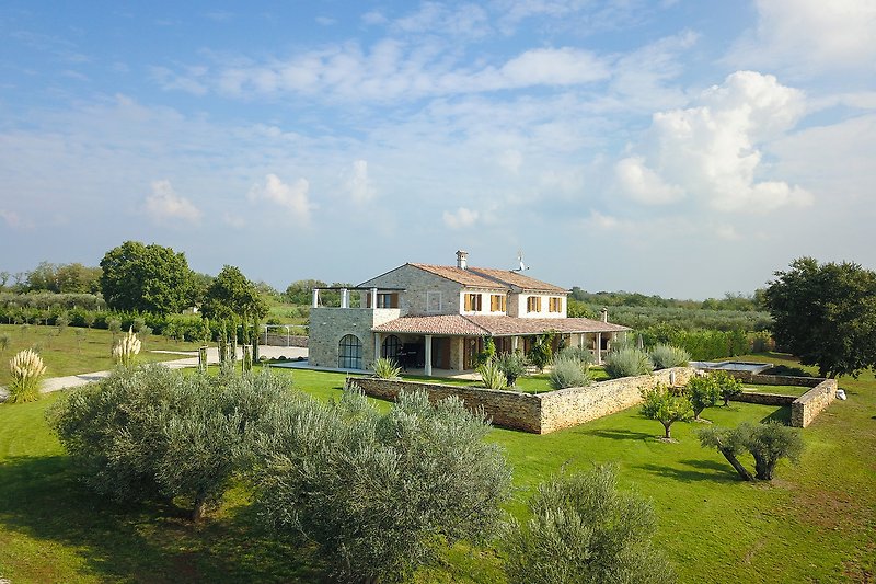 Wunderschöner Blick auf eine natürliche Landschaft mit einem Haus und Garten. Ideal zum Entspannen und Genießen des Urlaubs.